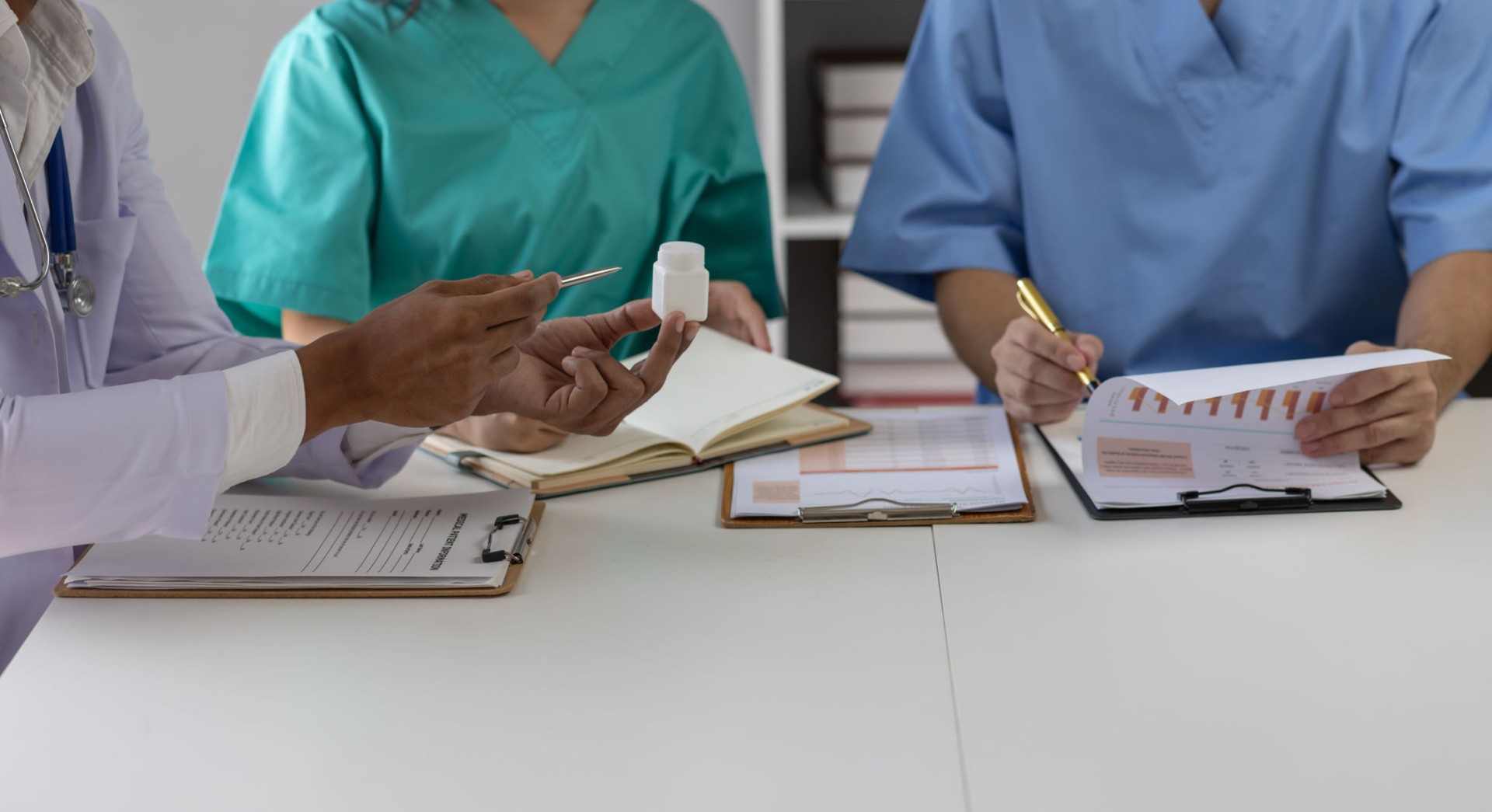 Medical, meeting and healthcare workers for team in office, discussion, brainstorming and planning. Doctor, nurse and computer on desk show diversity in collaboration or workshop for data analytics